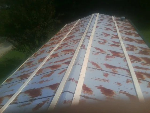 Rusted metal roof panels with new wood purlins before replacement — Storm Damage Roof Repair in Polkton by Roofing Brothers