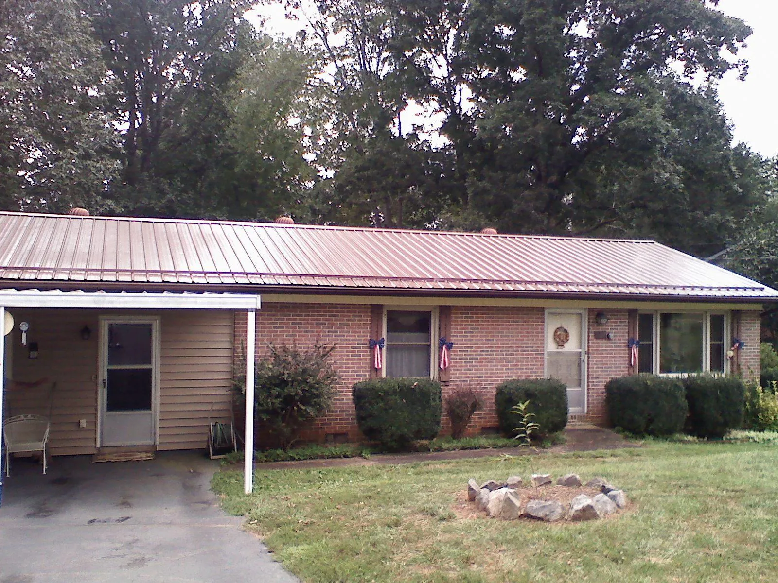 Bronze metal roof and carport on a brick ranch home — Roof Repair work by our crew in Polkton