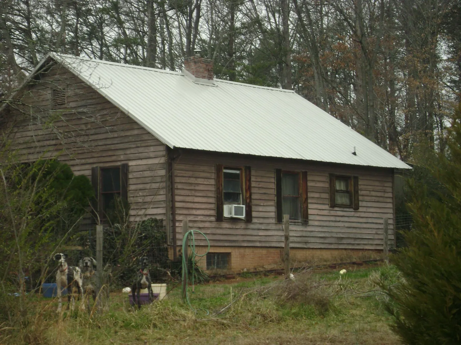 White metal roof on an old wood sided farmhouse, from a Metal Roof Installation job in Polkton
